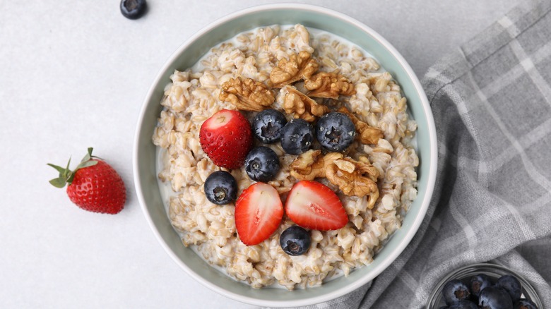 Bowl of oatmeal with berries and walnuts.