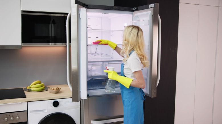 Person deep cleaning refrigerator