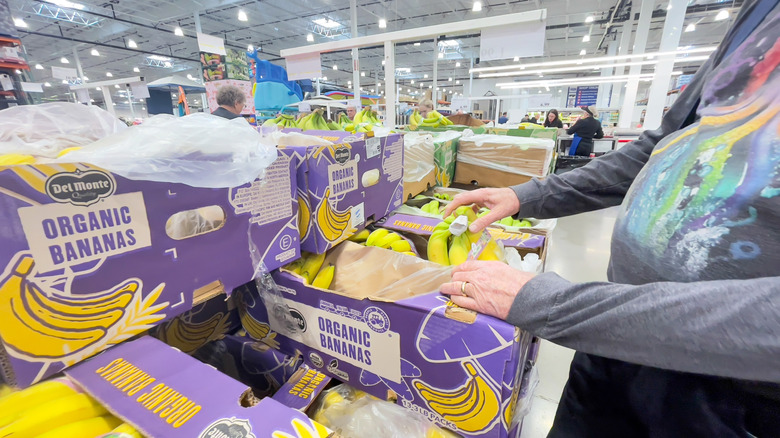 Shopper picking up bananas at Costco