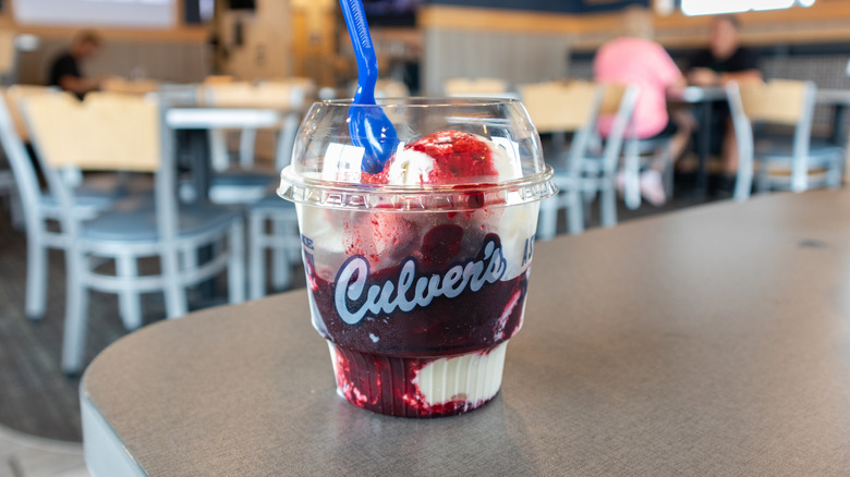 Cup of Culver's vanilla frozen custard with a red fruit mix-in.