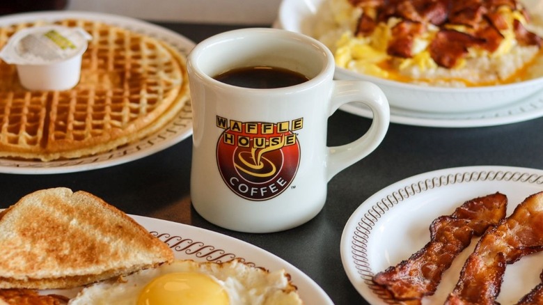 Waffle House mug with coffee surrounded by waffles, egg dishes, and bacon