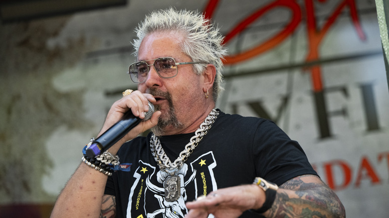 Guy Fieri speaks into a microphone.