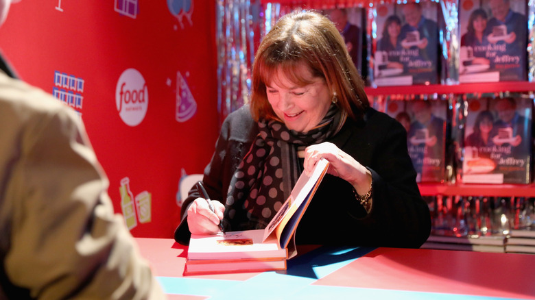 Ina Garten signing a cookbook.