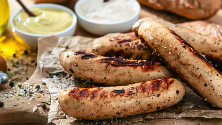 Grilled bratwurst on a cutting board.