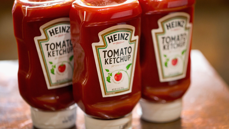 Containers of Heinz ketchup on a table.