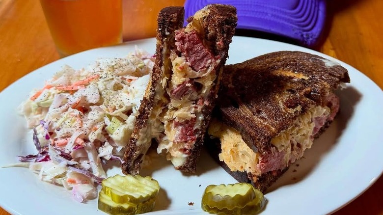 Crescent moon Reuben with coleslaw on a white plate