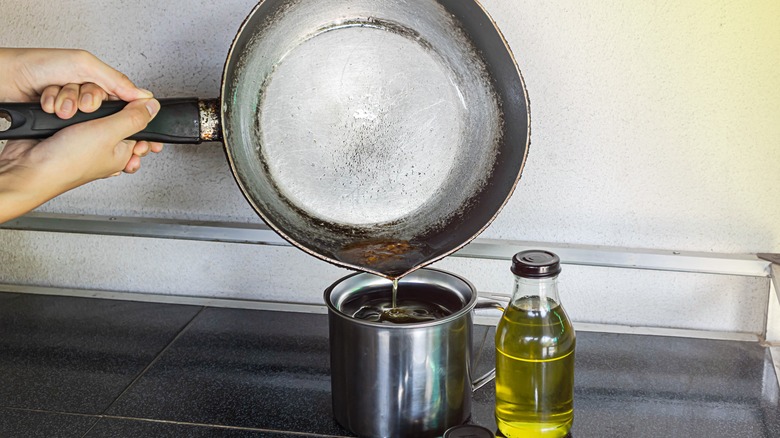 Oil being poured into a jug from a pan
