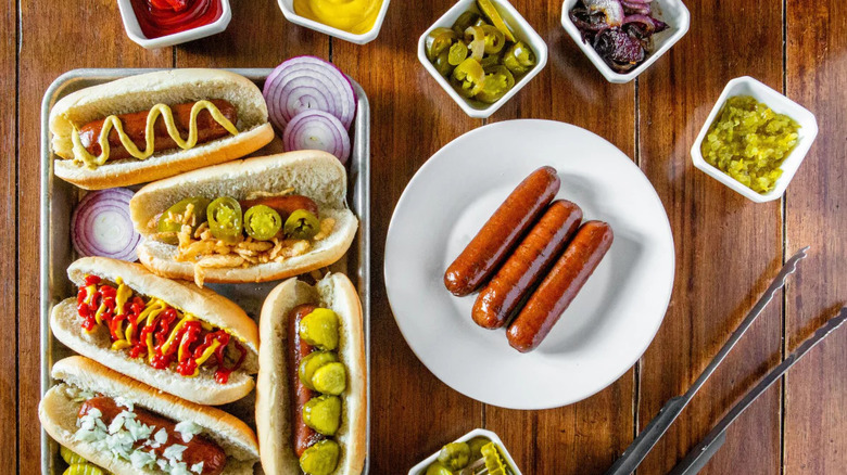 KC Cattle Company Wagyu Beef Hot Dogs on a white plate surrounded by condiments