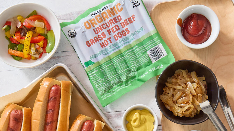 Trader Joe's Organic Uncured Grass Fed Beef Hot Dogs resting on a table surrounded by condiments