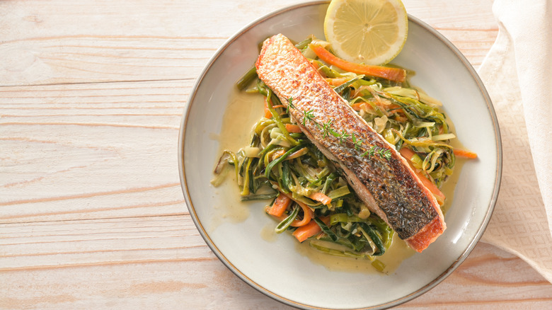 crispy salmon skin filet served over vegetable noodles