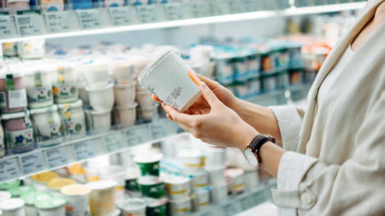 A shopper looks at different types of yogurt