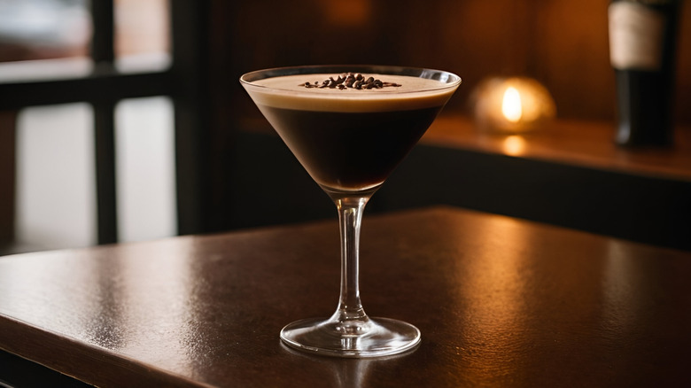 Espresso martini in a glass on a wood table.