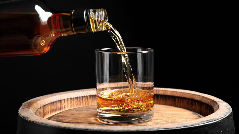 Pouring whiskey from bottle into glass