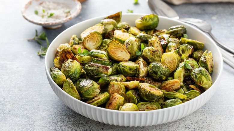 roasted brussels sprouts in a white dish placed on a gray table