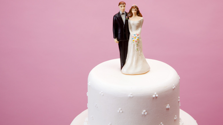 man and woman topper on white wedding cake