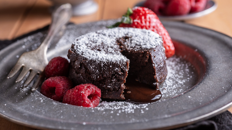 A chocolate lava cake with raspberries and strawberries