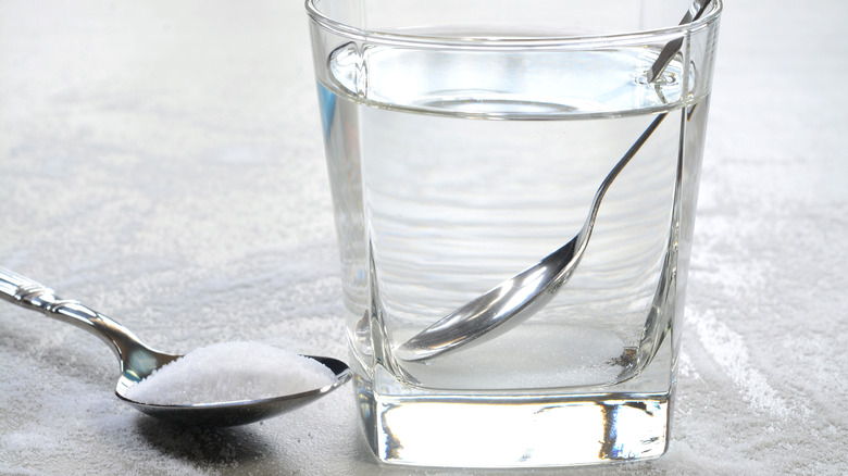 glass of water next to spoonful of salt