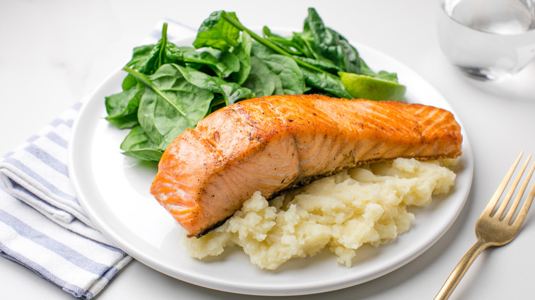 Salmon served with spinach and mashed potato.