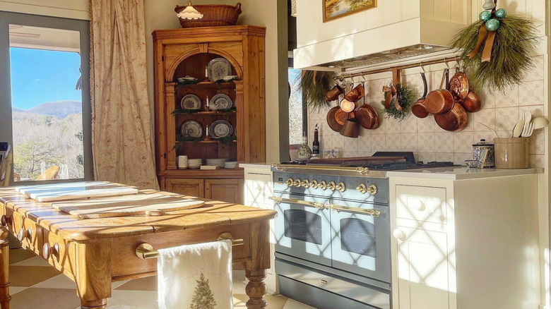 an unfitted kitchen with flowers on a wooden table