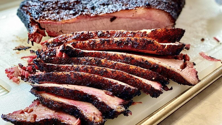 Brisket cut into slices on cutting board