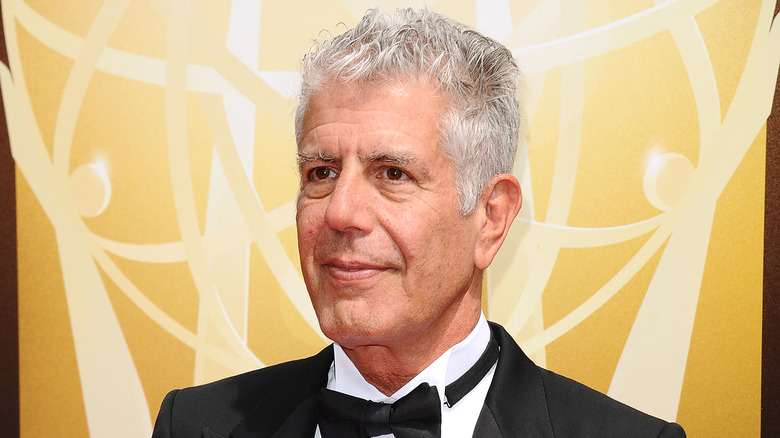 Anthony Bourdain with bow tie against yellow background