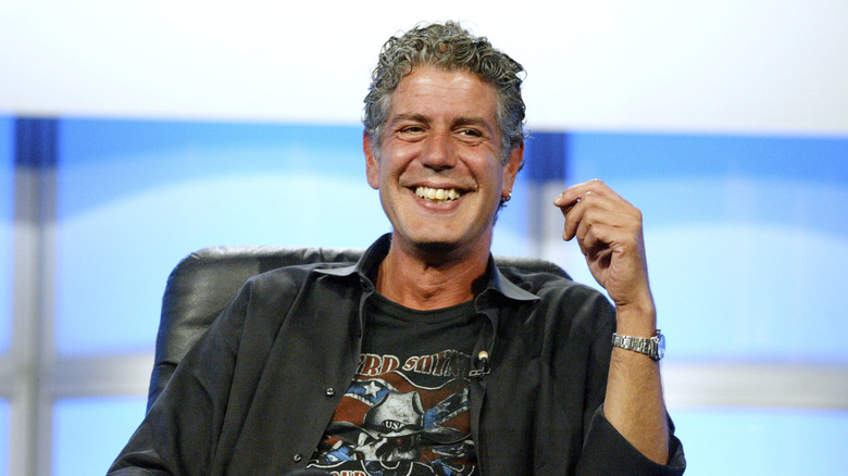 Anthony Bourdain laughing in a chair