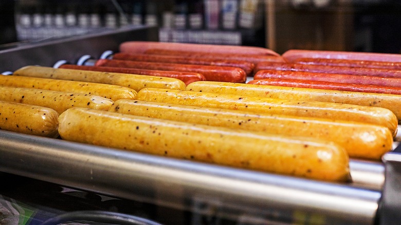 Hot dogs and sausages cooking on gas station rollers