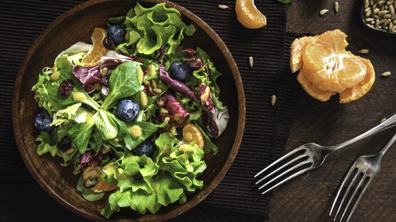 Mixed green salad in wooden bowl