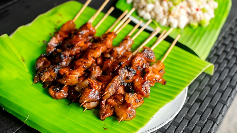 barbecue meat skewers on banana leaves