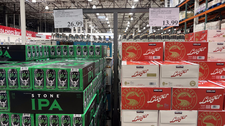 Cases of Stone IPA and Kirkland Lager sit in a stack at a Costco