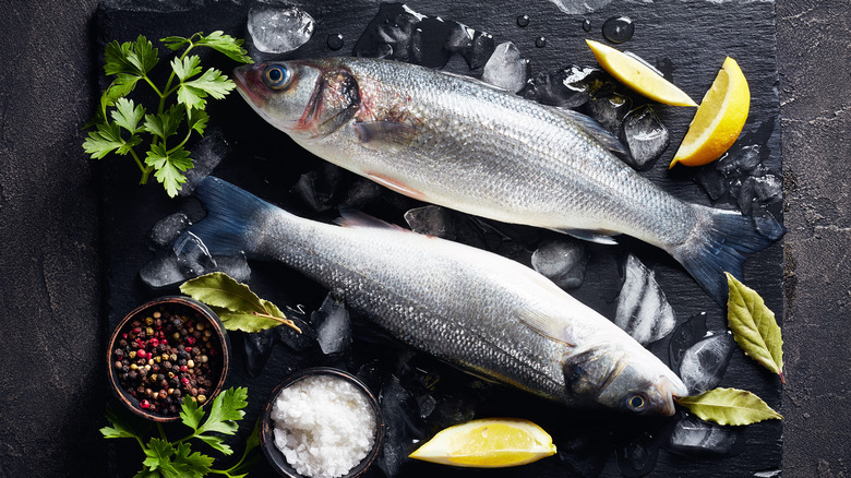 Raw branzino on marble slab with seasonings