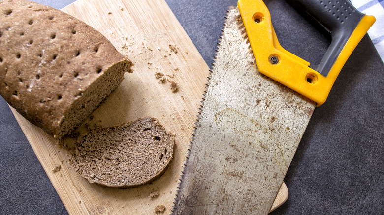 Stale loaf of bread next to saw