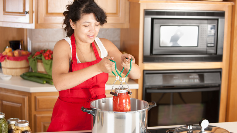 Woman canning food in her kitchen