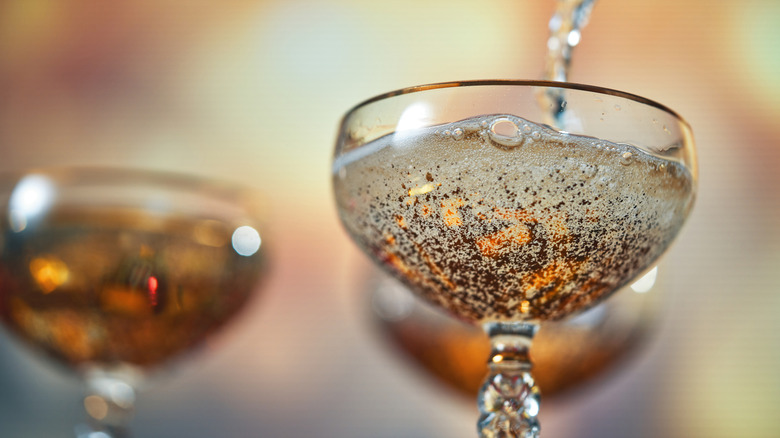 Champagne is poured into a coupe glass.