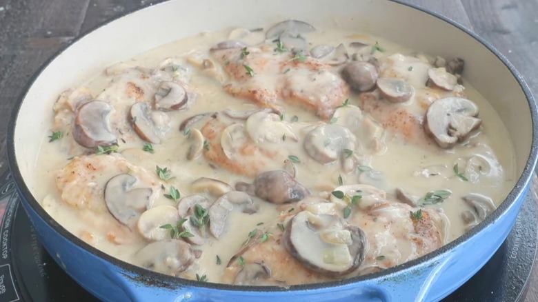 Champagne chicken in a pot with fresh thyme.