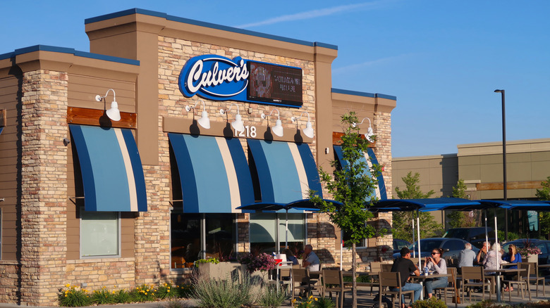 Tan and white front of building with blue and white Culver's sign and window awnings