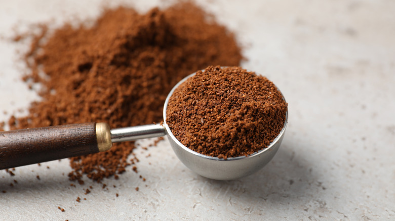 A coffe scoop holding ground coffee.