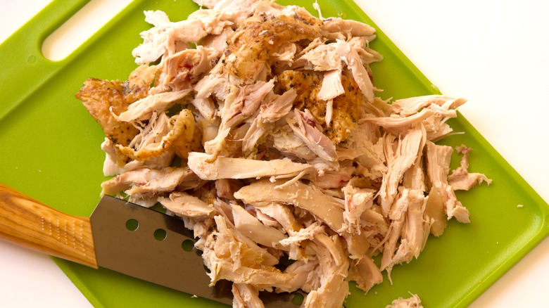 shredded rotisserie chicken on cutting board