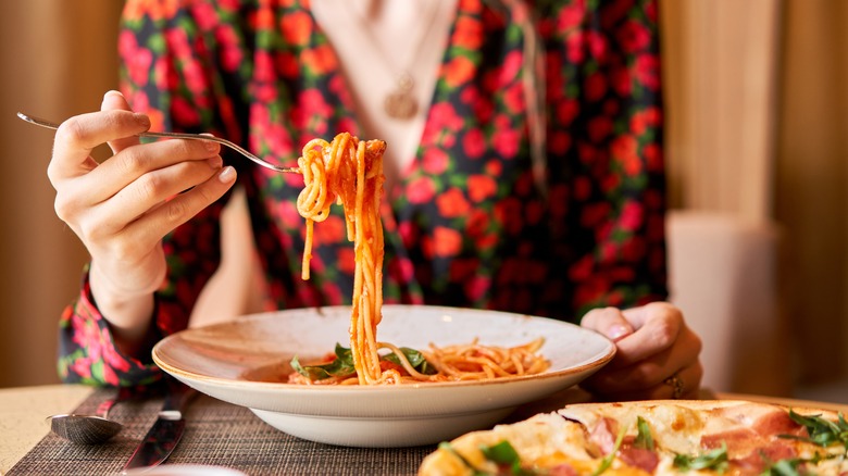 Woman holding fork full of spaghetti