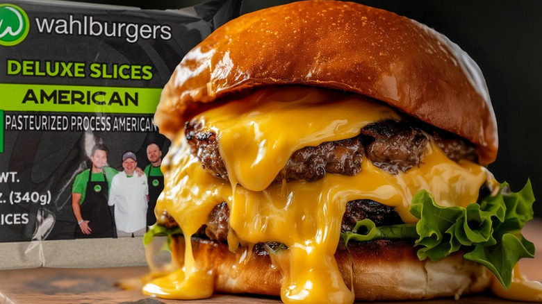 A Wahlburger with dripping cheese in front of a package of American cheese slices.