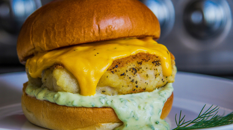 Fish burger with cheese and dill sauce