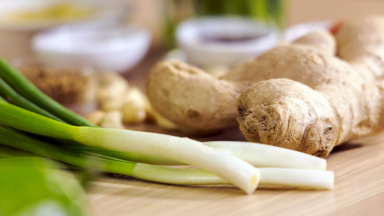 fresh ginger, scallions, and garlic on cutting board