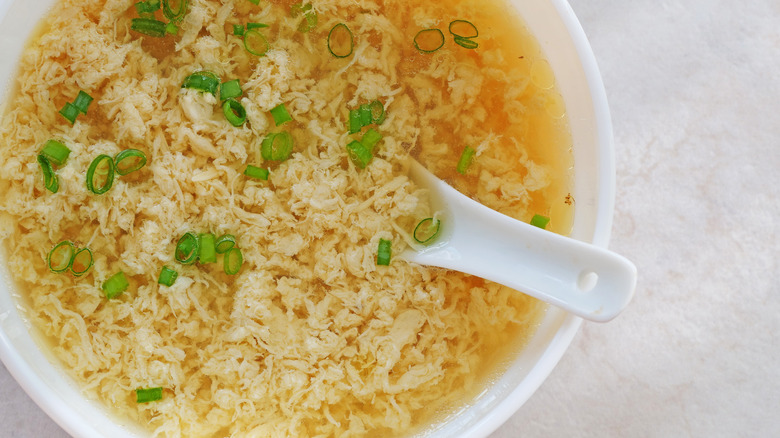 overhead shot of egg drop soup in a white bowl