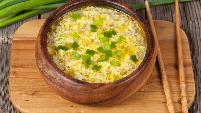 wooden bowl of egg drop soup with chopsticks