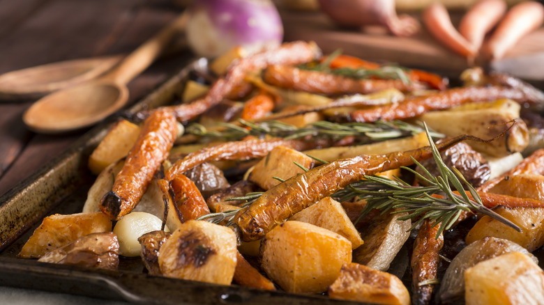 Roasted vegetables on baking pan with herbs