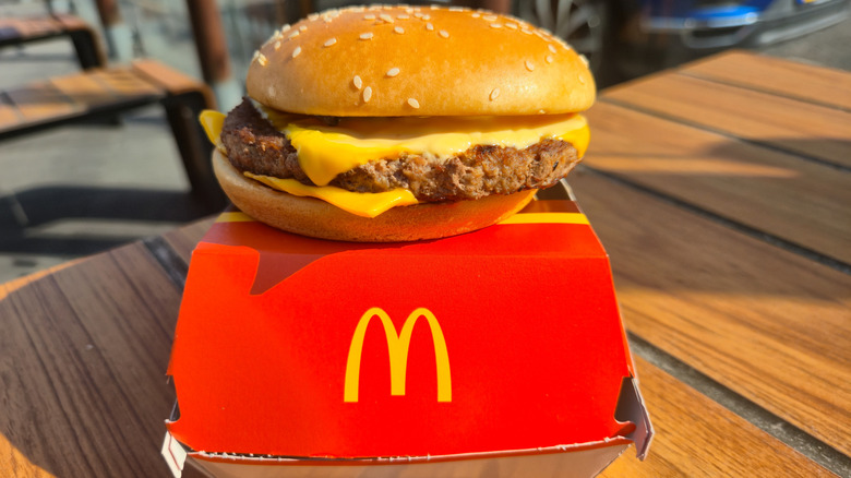 A McDonald's burger sits on top of a red and yellow box.