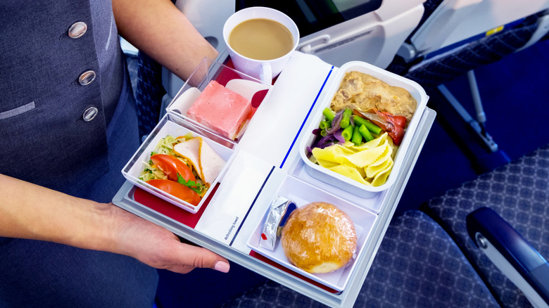 A person holding a tray of food