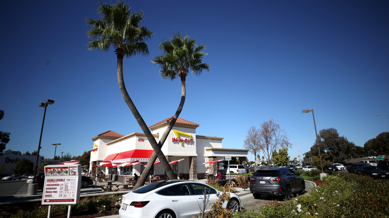 Two crossed palm trees outside of an In-N-Out location