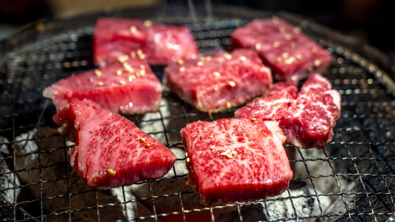 Cuts of A5 Japanese wagyu beef being grilled for yakiniku