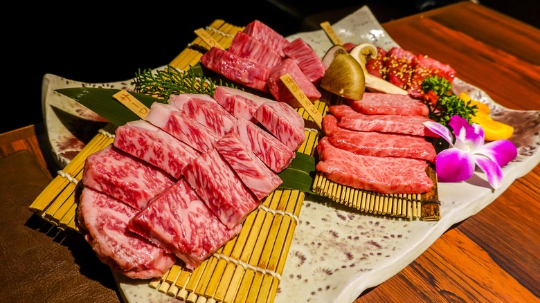 Raw wagyu slices on a plate with edible flowers